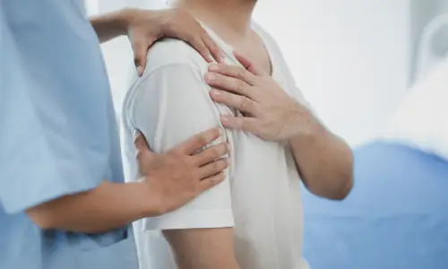 A man receiving a shoulder pain treatment from a medical pratitioner.
